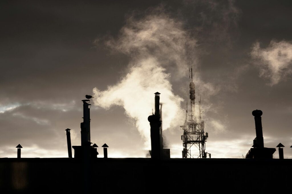 silhouette of factory under cloudy sky