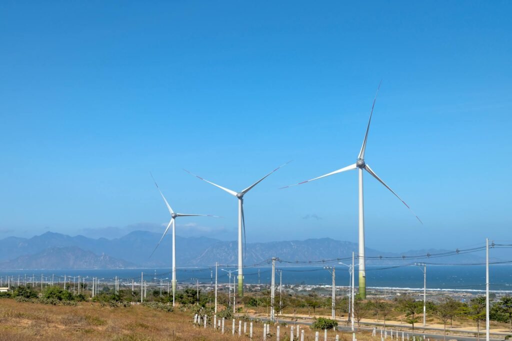 windmills against sea and ridges under blue sky