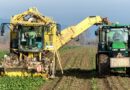 harvester passing crops into trailer