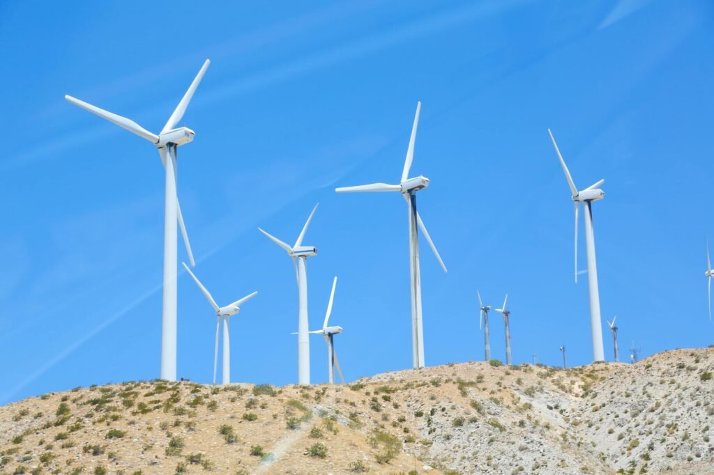 rows of wind turbines on slope in field