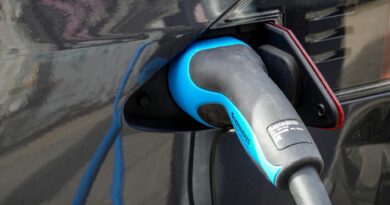 a blue and black gas pump nozzle in a vehicle gas tank