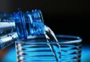 close up of bottle pouring water on glass