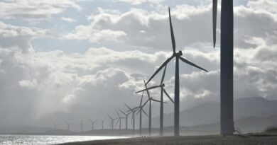 windmills on seashore under white clouds
