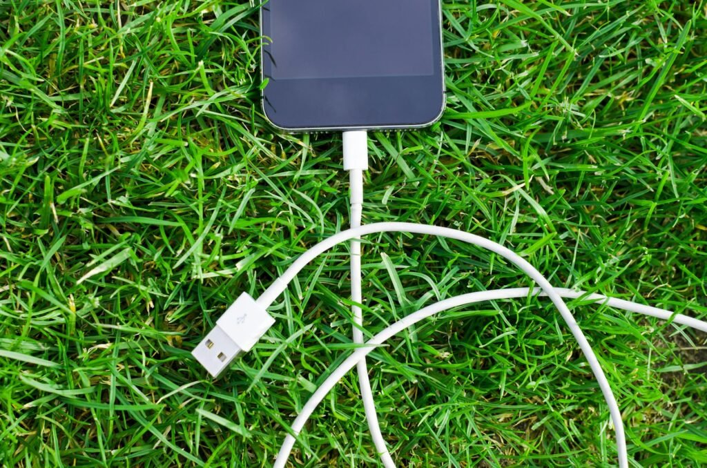 black ipod touch and cable on grass