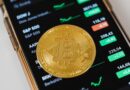 gold round coin on top of a cellphone