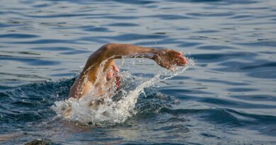 person swimming on body of water doing freestyle strokes