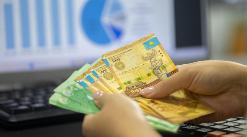 kazakhstan tenge notes with financial graphs in background