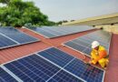 a male solar technician installing a solar panel