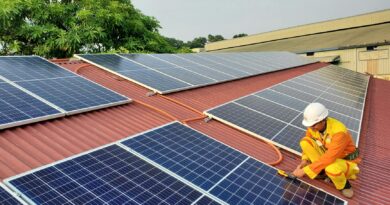a male solar technician installing a solar panel