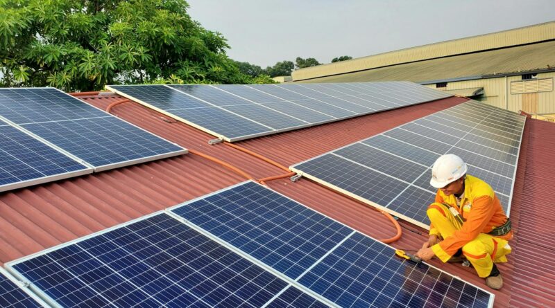 a male solar technician installing a solar panel
