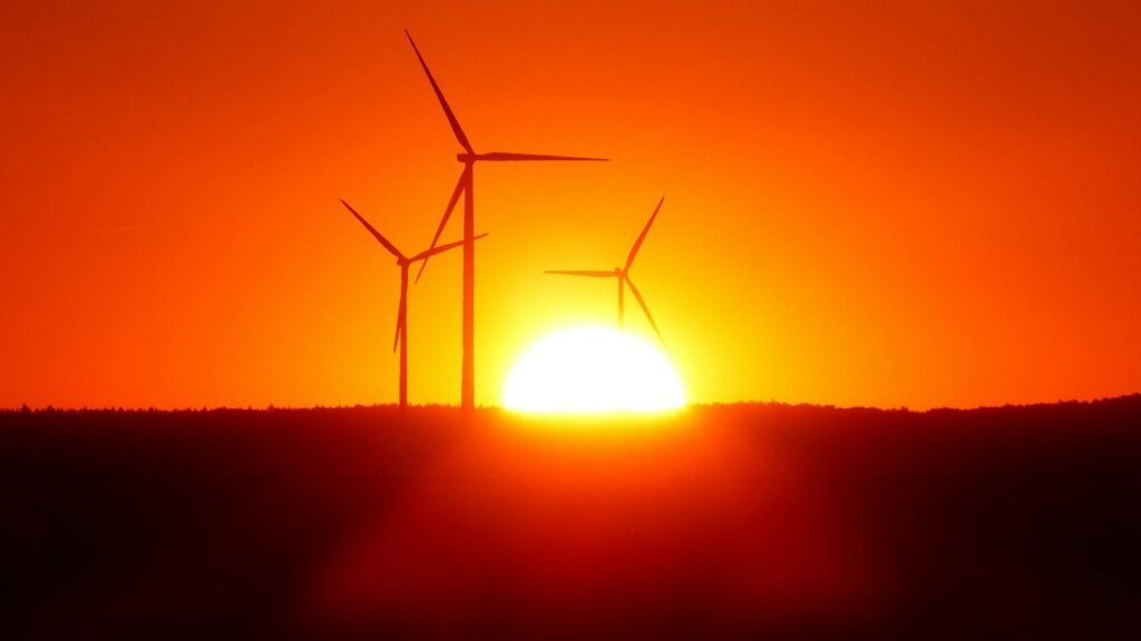 silhouette of wind turbines at sunset