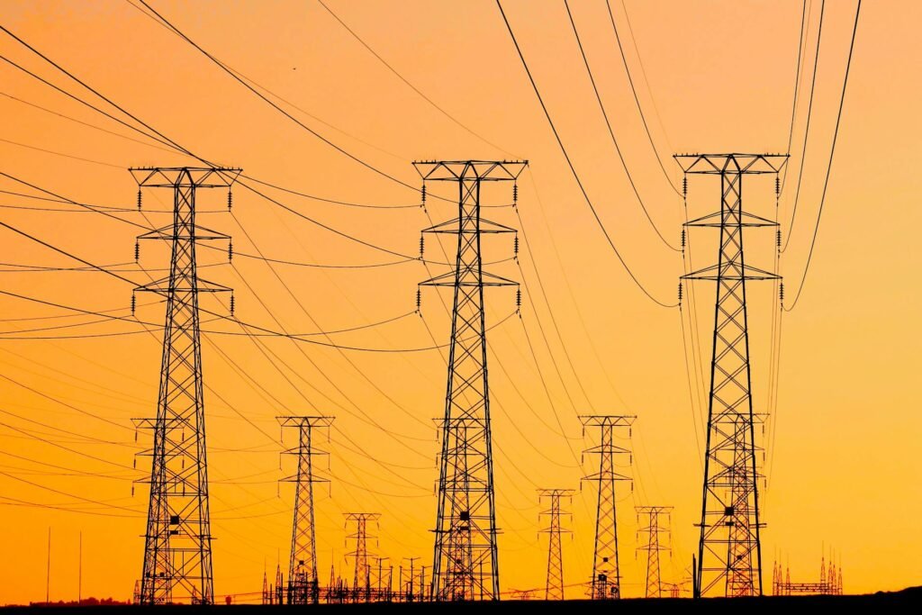 high voltage transmission towers at sunset