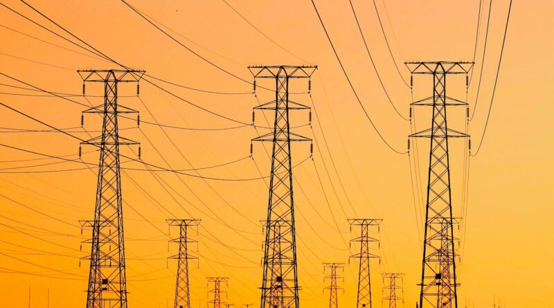 high voltage transmission towers at sunset