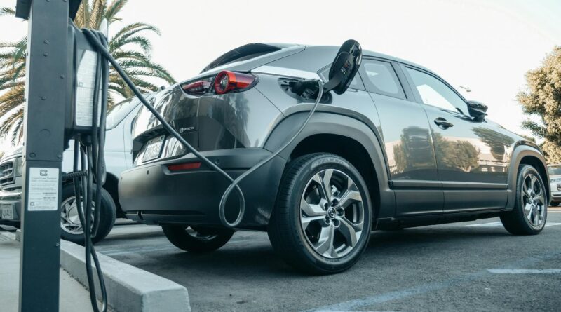 gray electric car parked on a charging bay