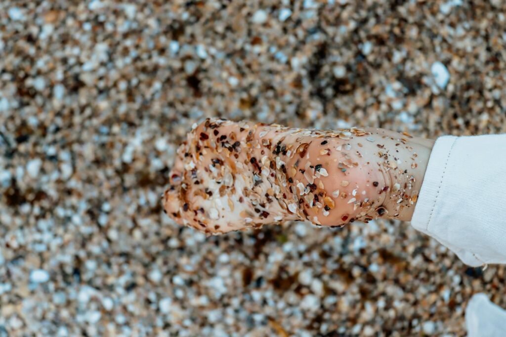 brown and white stone fragments on a person s bare foot