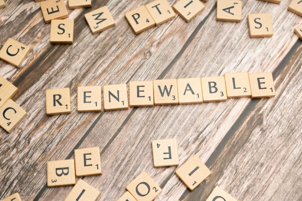 the word renewable written in scrabble letters on a wooden table