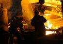 men in helmet standing beside steel melting pool