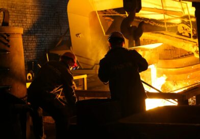 men in helmet standing beside steel melting pool
