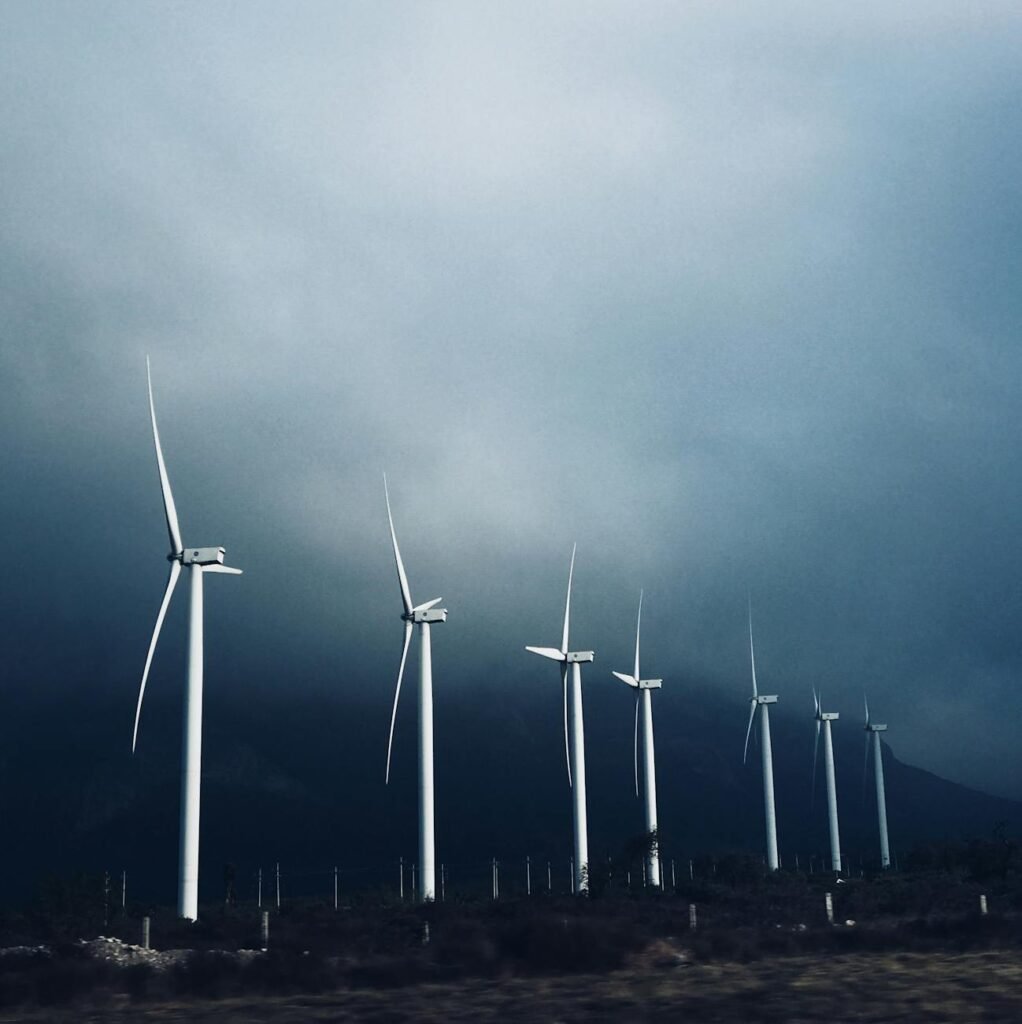white wind turbines under white clouds