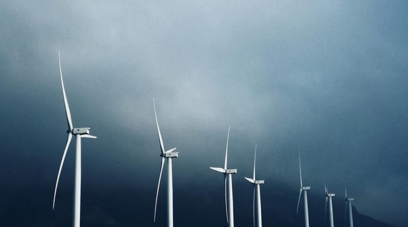white wind turbines under white clouds