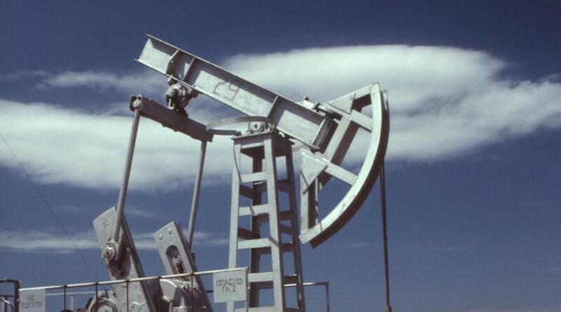 a gray steel pumpjack under blue sky
